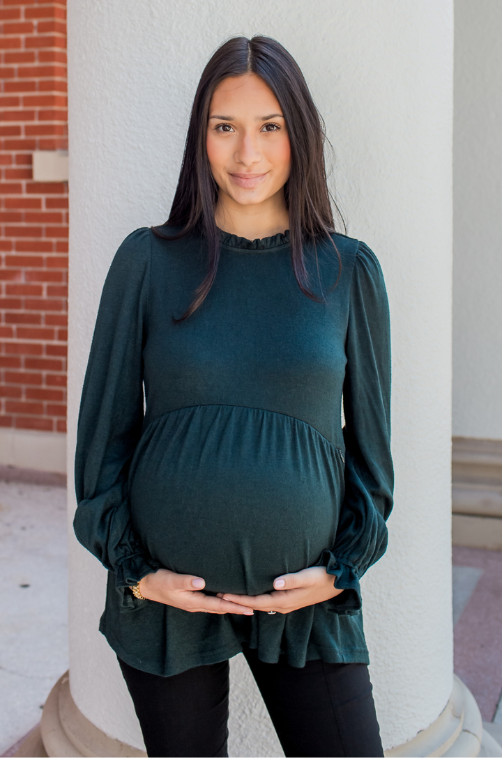 Pregnant model wearing the babydoll nursing sweater in deep green, showing a comfortable maternity fit.