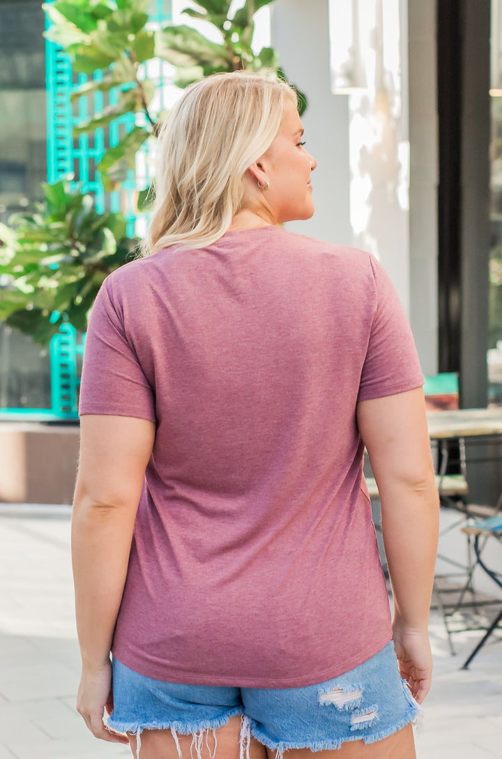 Back view of a woman wearing a nursing and pumping shirt in heather plum.