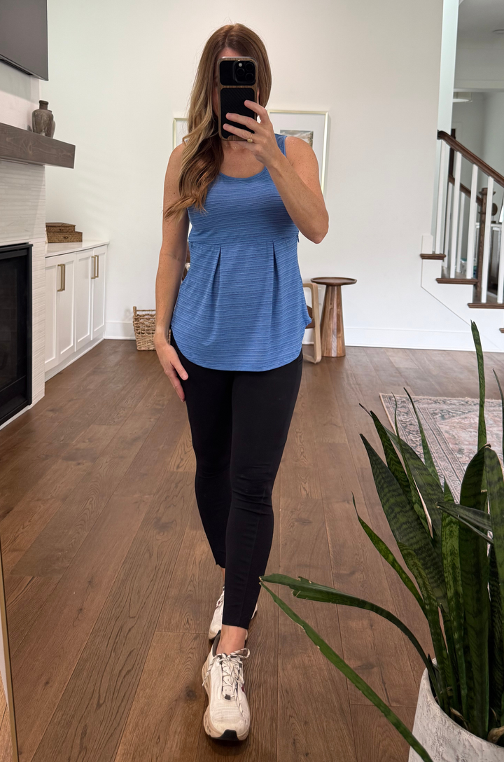 mom wearing a zipper breastfeeding workout tank top in blue with front pleats and empire waist for nursing or pumping