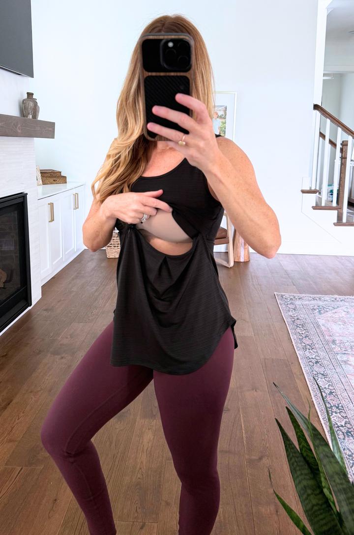 mom wearing a workout black breastfeeding workout top with opening for nursing or pumping.