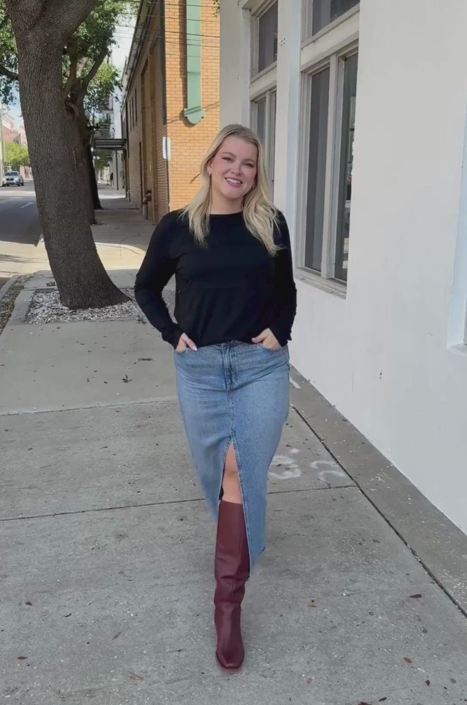 Mom wearing long sleeve nursing shirt in black with hidden breastfeeding access
