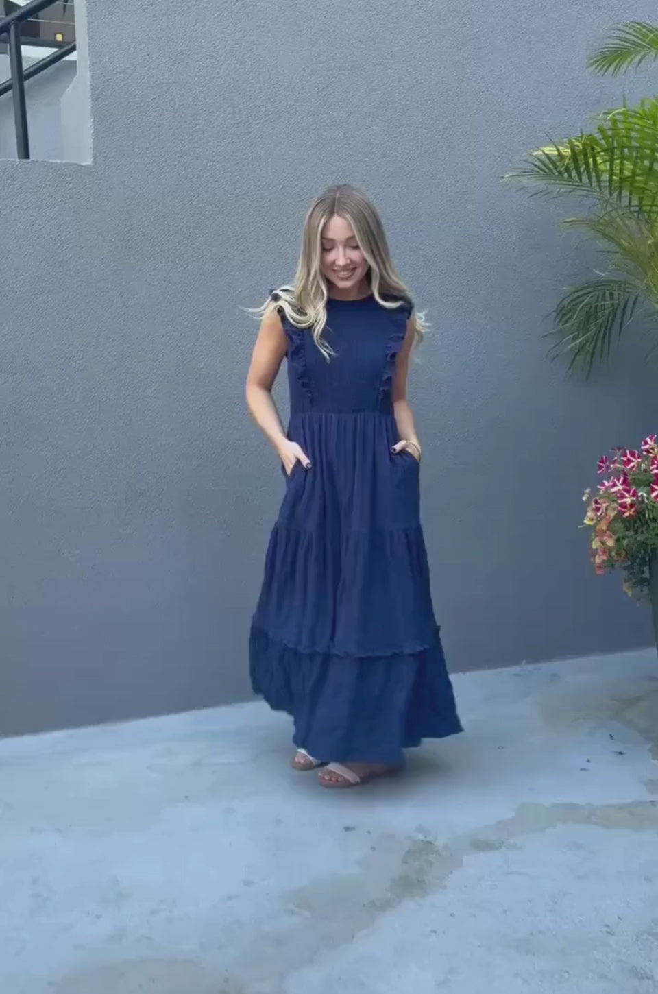 Woman wearing a Navy cotton nursing dress with pockets and hidden breastfeeding access. 
