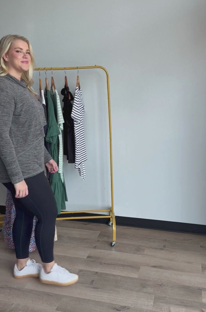 Video showing close-up demonstration of asymmetrical flap opening on nursing sweater, revealing inner layer for breastfeeding access
