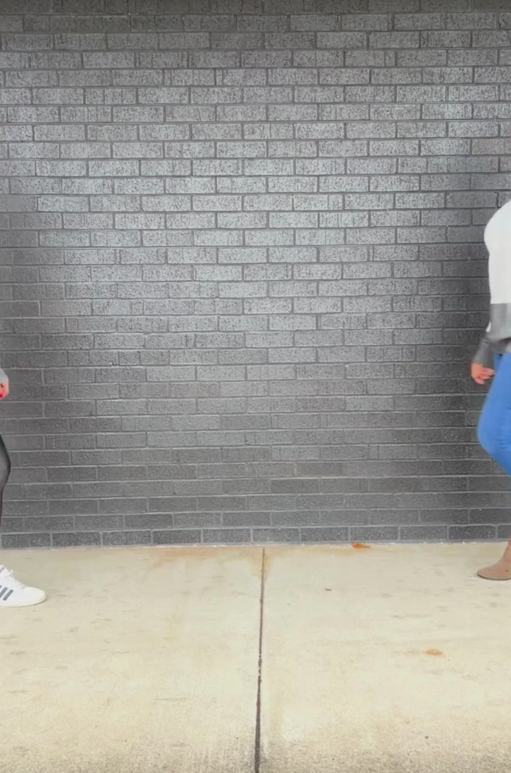 Video showing two moms walking toward the camera wearing the gray colorblock fuzzy nursing sweater, then opening the concealed access to demonstrate breastfeeding functionality.