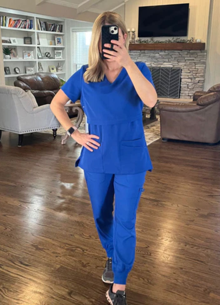 model wearing a royal blue breastfeeding scrub top with matching pants