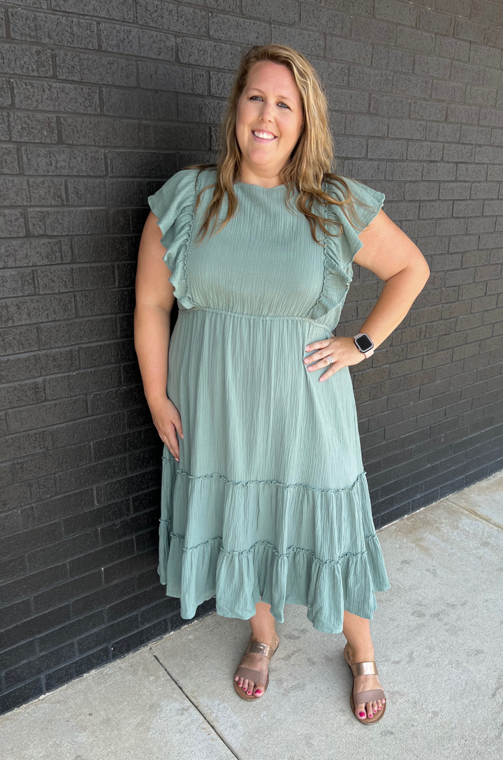 The gauze midi dress in seafoam green is shown from the front on a mom, highlighting its breezy fabric and flattering fit.