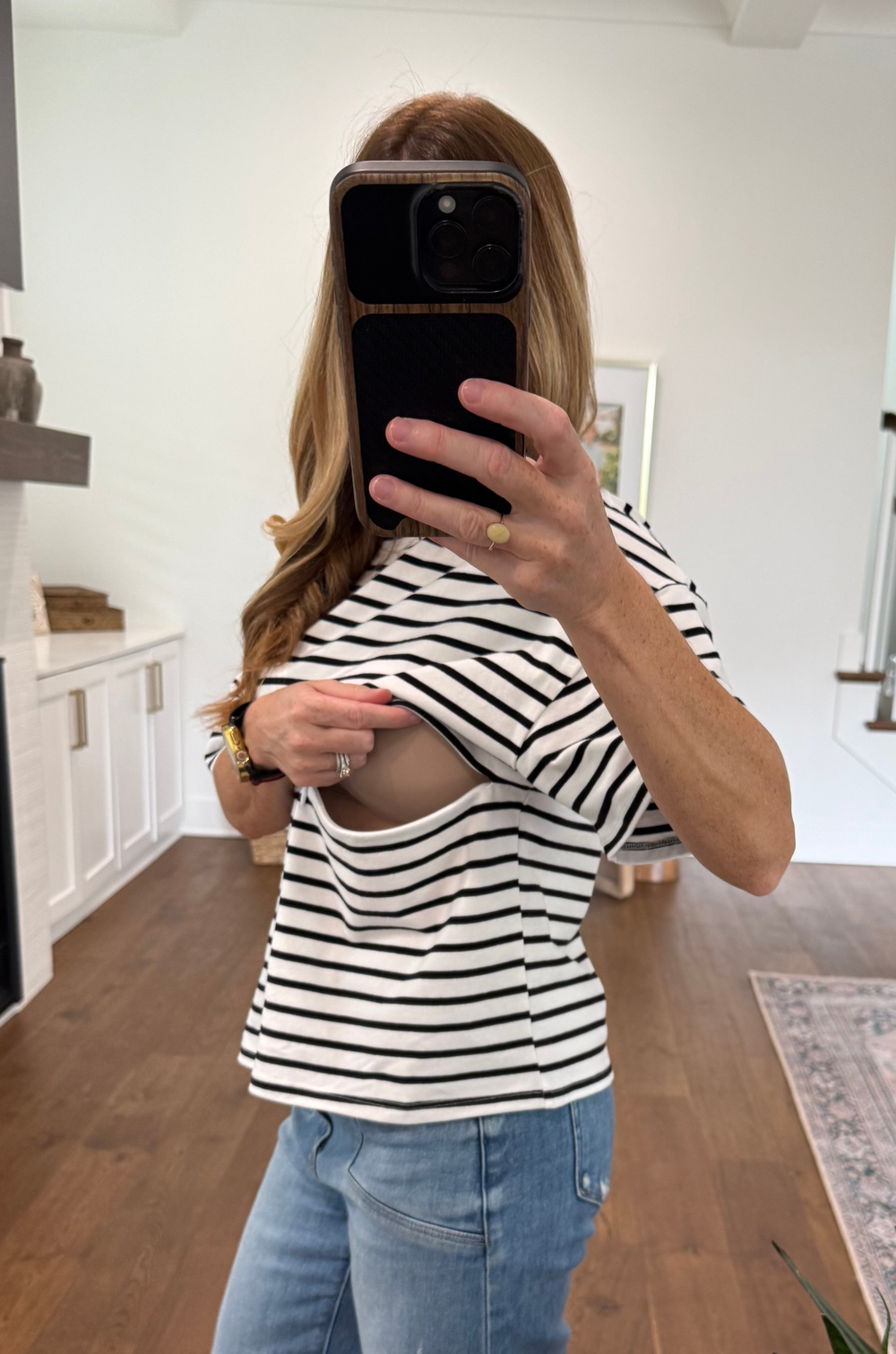 woman showing the hidden zipper nursing access for breastfeeding in black and white striped tee