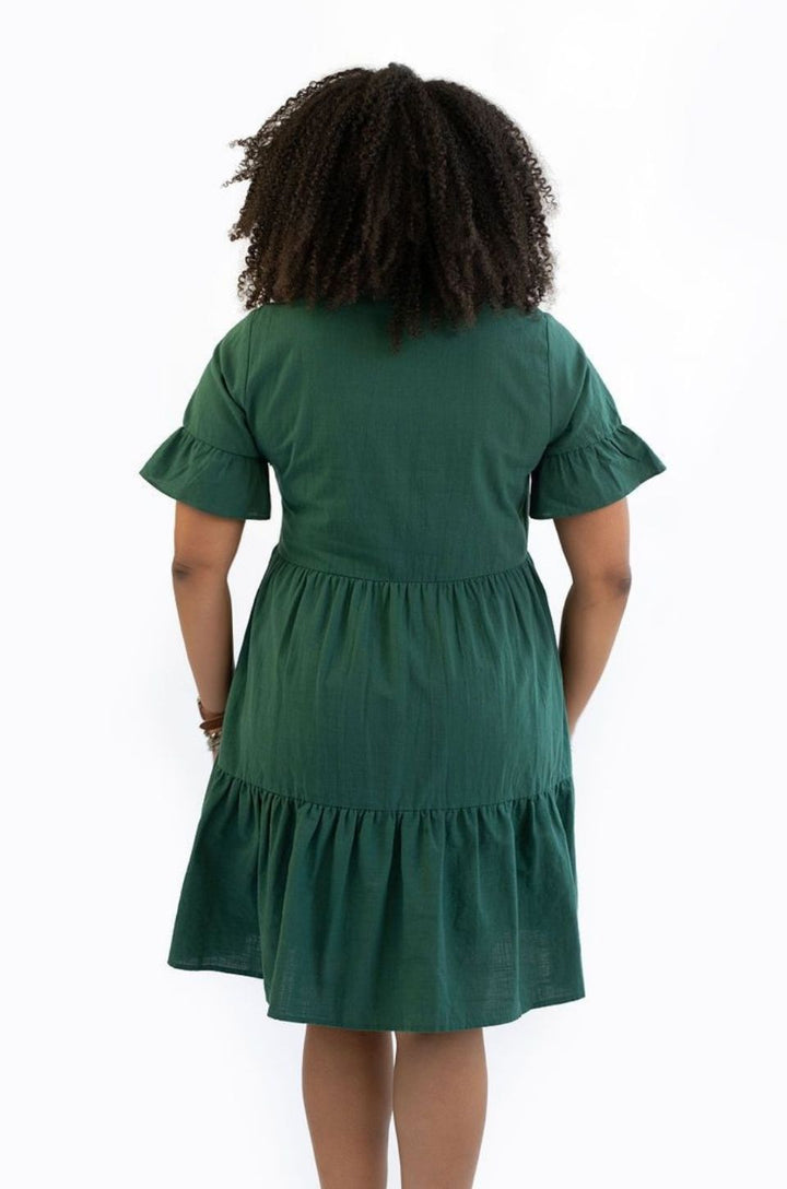 The green bell sleeve breastfeeding dress with pockets is shown from the back with a loose, flattering silhouette.