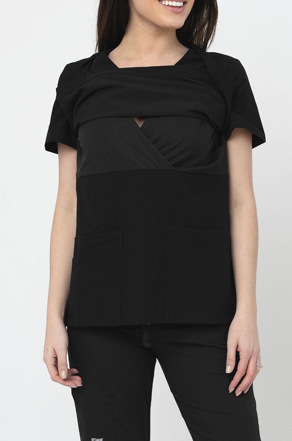 Front view of breastfeeding scrub top lifted up to show the nursing access. 